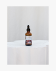 A bottle of Roseum Essential Oils with a dropper, on a white background.