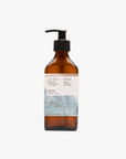 A recycled amber glass pump bottle of La-Eva Spice Hand & Body wash with a label featuring artwork by Emma Cassi, Spicy wash; ginger, patchouli, cinnamon