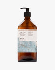 A recycled amber glass pump bottle of La-Eva Spice Hand & Body wash with a label featuring artwork by Emma Cassi, Spicy wash; ginger, patchouli, cinnamon