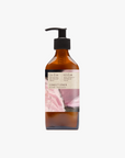 A recycled amber glass pump bottle of Roseum Conditioner with a label featuring 'Flamingos' artwork by Meinke Flessemen and the text 'roséum' part of the rose geranium botanical, Pelargonium roseum.