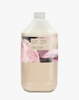 A 5L jerrycan bottle of LA-EVA conditioner refill with a label featuring 'Flamingos' artwork by Meinke Flessemen, indicating the rose geranium botanical and floral fragrance.