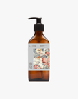 A recycled amber glass pump bottle of La-eva Roseum Hand & Body lotion with a label featuring 'Younger Together' artwork by Valeska Hykel and the text 'roséum ', part of the rose geranium botanical, Pelargonium roseum.