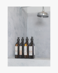 Set of five bottles of La-Eva spice collection with labels by Emma Cassi on a marble shelf against a marble wall.