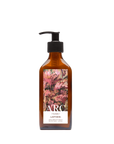 A recycled amber glass pump bottle of Roseum Hand & Body Lotion with bespoke artwork for ARC architecture by artist Beatrice Hassel McCosh.