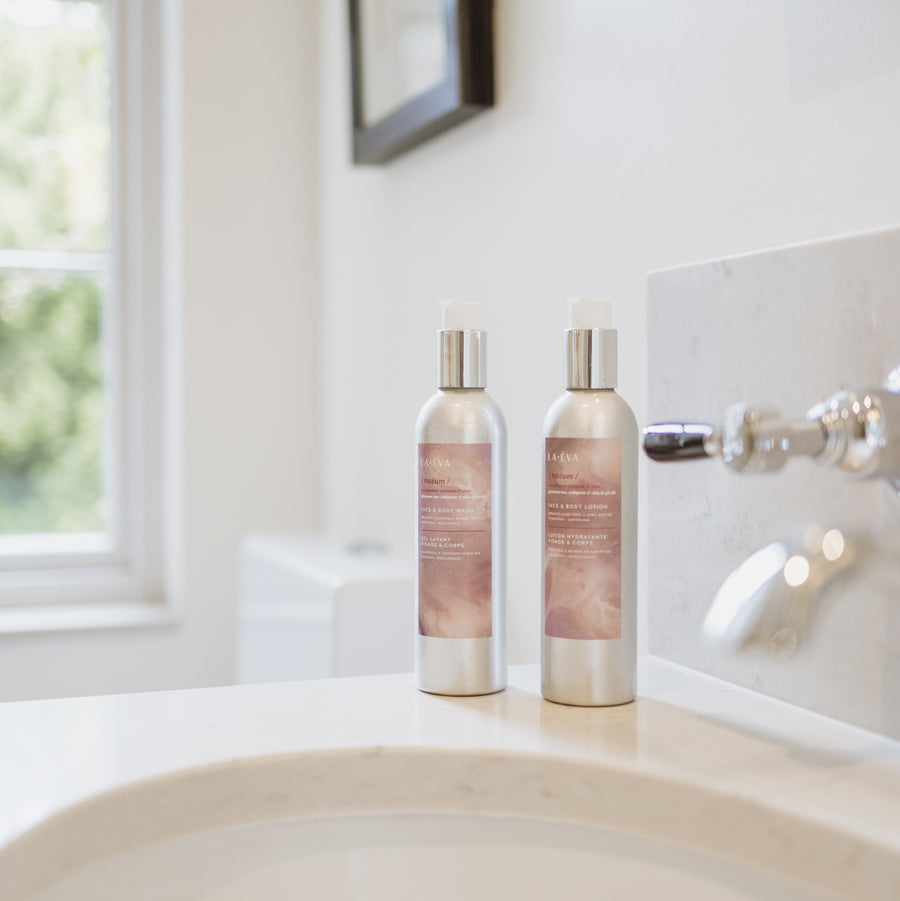 200ml aluminium bottle of La-Eva Roseum face and body wash with a 200ml aluminium bottle of La-Eva Roseum face and body lotion set in a hotel bathroom of the Oxford Collection 