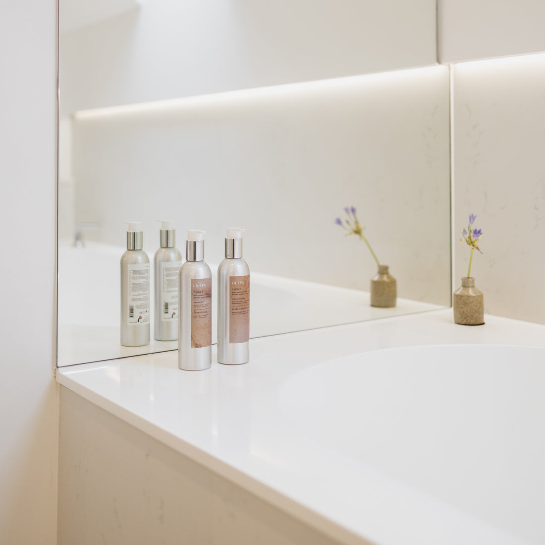 two 200ml aluminium bottles of La-Eva Spice shampoo and conditioner photographed in the hotel bathroom of the Oxford Collection
