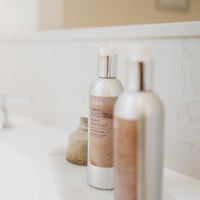 2 aluminium bottles of La-Eva Spice shampoo and conditioner photographed in the hotel bathroom of the Oxford Collection