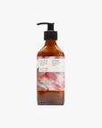 A 200ml recycled amber glass pump bottle of Roseum Hand & Body Lotion with a label featuring 'Flamingos' artwork by Meinke Flessemen and the text 'roséum' part of the rose geranium botanical, Pelargonium roseum.