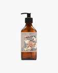 A recycled amber glass pump bottle of La-eva Roseum Hand & Body wash with a label featuring 'Younger Together' artwork by Valeska Hykel and the text 'roséum ', part of the rose geranium botanical, Pelargonium roseum.