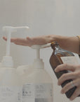 A 5-litre bottle of La-Eva Blu hand and body wash and lotion being filled into recycle amber glass pump bottle