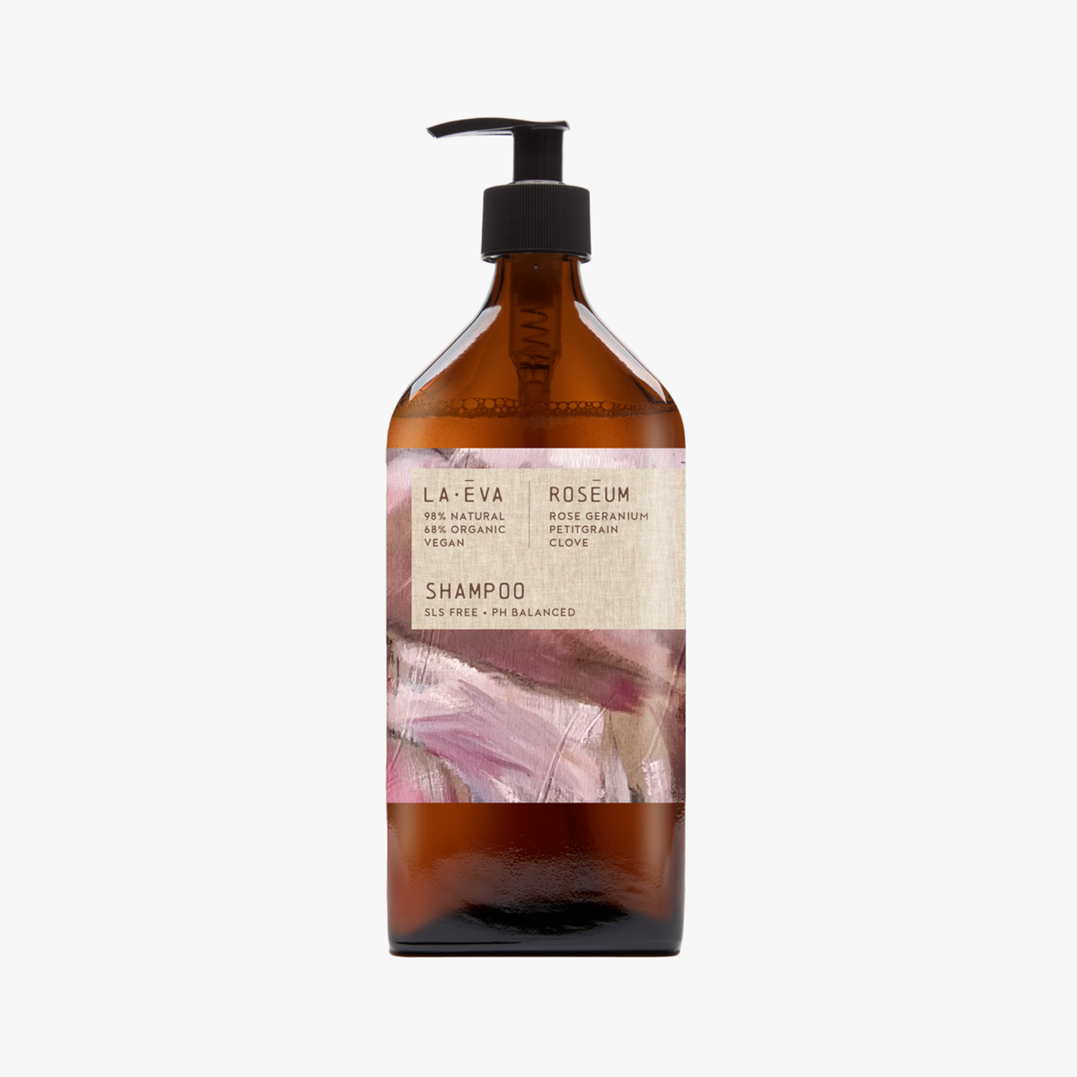 A recycled amber glass pump bottle of Roseum Shampoo with a label featuring 'Flamingos' artwork by Meinke Flessemen and the text 'roséum' part of the rose geranium botanical, Pelargonium roseum.
