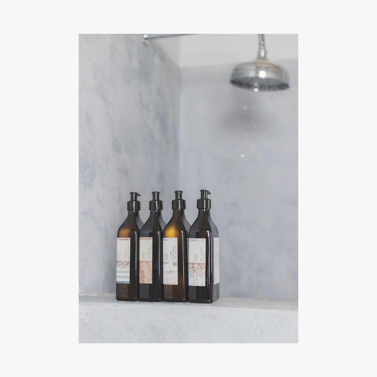 Set of five bottles of La-Eva spice collection with labels by Emma Cassi on a marble shelf against a marble wall.