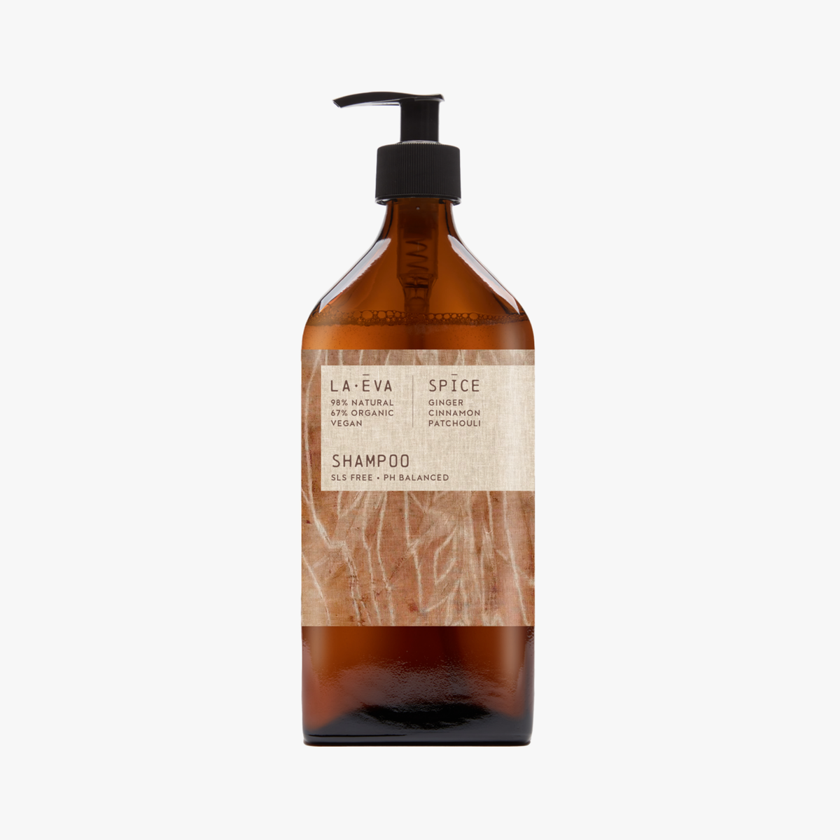 A recycled amber glass pump bottle of La-Eva Spice shampoo with a label featuring artwork by Emma Cassi,  Spicy wash; ginger, patchouli, cinnamon