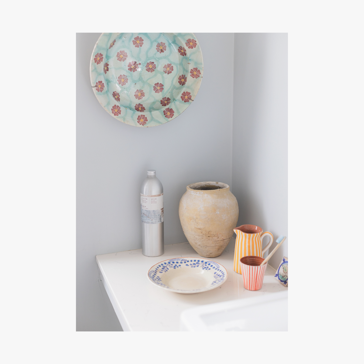 Casa Cubita ceramic plates and vases on a white surface against a light grey wall with spicy la-eva wash 