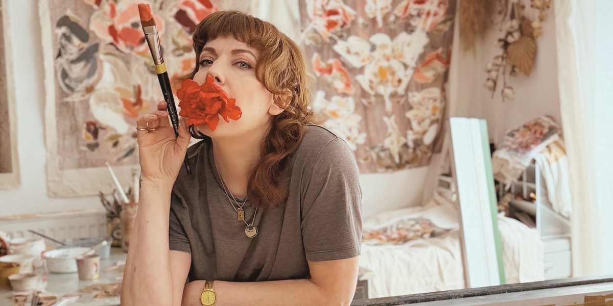 Valeska Hykel in her studio with original artwork in the background